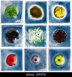 Raccolta di blu smaltate a mano le piastrelle di ceramica con altri punti di colore in mezzo isolato su sfondo bianco. Ceramiche colorate gli oggetti artigianali. Foto Stock