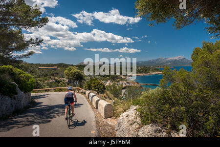 Ciclista femmina persona escursioni in bicicletta su una bici da strada e di tornare indietro dal Cap des Pinar, Mallorca, Maiorca, isole Baleari, Spagna Foto Stock