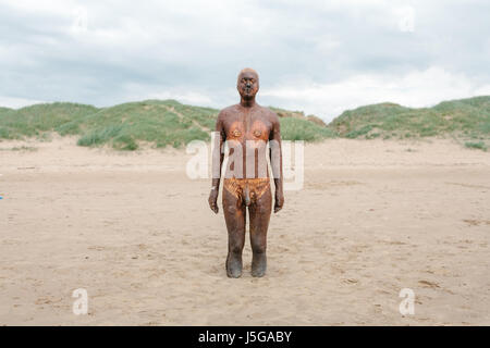 Una delle statue in un altro luogo della installazione di Antony Gormley su Crosby Beach, Liverpool, in Inghilterra Foto Stock