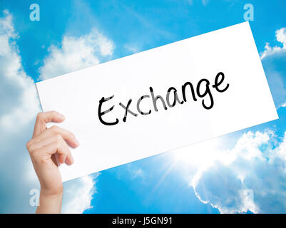 Segno di Exchange su carta bianca. Man mano che tiene la carta con testo. Isolato su sfondo cielo. Il concetto di business. Stock Photo Foto Stock