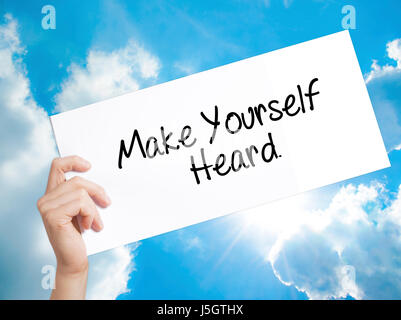 Fai sentire la tua voce segno su carta bianca. Man mano che tiene la carta con testo. Isolato su sfondo cielo. Il concetto di business. Stock Photo Foto Stock