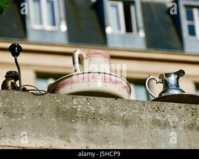 Lo zoom in brocche e la vecchia lampada sul muro di cemento a Parigi fiera antiquaria. Foto Stock