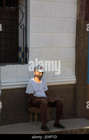 Uomo cubano seduto su un marciapiede in Ttrinidad Cuba Foto Stock