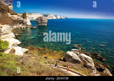 Coppia giovane kayak vicino a Bonifacio cittadina sulla splendida roccia bianca scogliera con Baia Mare, Corsica, Francia, Europa. Foto Stock