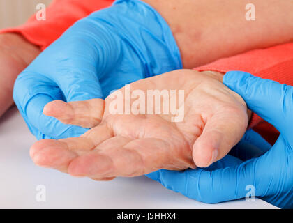 Il caregiver tenendo i pazienti anziani mano a casa Foto Stock