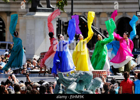 London, Regno Unito - 9 Agosto 2015: di etnia coreana ballerini eseguono danza tradizionale in coreano la festa a Trafalgar Square, spettatori presenti. Foto Stock