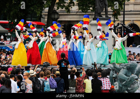 London, Regno Unito - 9 Agosto 2015: di etnia coreana ballerini eseguono danza tradizionale in coreano la festa a Trafalgar Square, spettatori presenti. Foto Stock