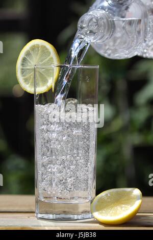 Acqua frizzante versando in vetro Foto Stock