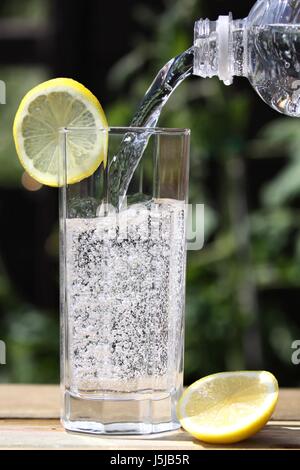 Acqua frizzante versando in vetro Foto Stock