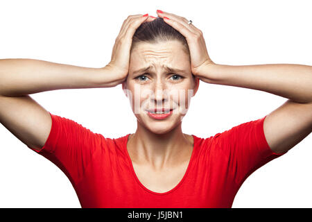 Ritratto di triste donna infelice in t-shirt rossa con le lentiggini. studio shot. isolato su sfondo bianco. Foto Stock