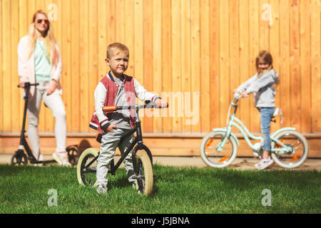 Donna con bambini su biciclette Foto Stock