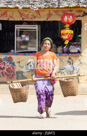 Donna che la porta di cestelli in Kuomintang villaggio cinese di Mae Aw o Baan Rak Thai, Mae Hong Son, Thailandia Foto Stock