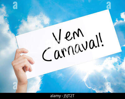Il carnevale è venuta (in portoghese) firmare su carta bianca. Man mano che tiene la carta con testo. Isolato su sfondo cielo. Il concetto di business. Stock Photo Foto Stock