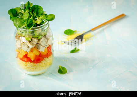 Vegan insalata con cuscus, tofu e verdure in un vaso. Amore per un sano cibo vegan concept Foto Stock