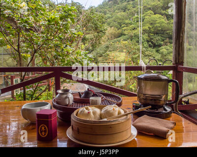 Maokong, Taiwan - 19 Ottobre 2016: un tavolino da tè con accessori in un locale di casa da tè sulle colline di Maokong Taiwan. E la vista per la piantagione di tè Foto Stock
