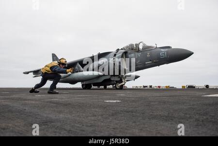 Un U.S. Navy sailor segnali per un Marine Corps AV-8B Harrier II massa-attacco decollo dal ponte di volo a bordo della USN Wasp-classe assalto anfibio nave USS Makin Island il 11 maggio 2017 nell'Oceano Pacifico. (Foto di MCS3 Devin M. Langer /US Navy via Planetpix) Foto Stock