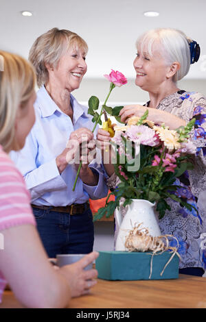 Donne riuniti a decorazione floreale di classe Foto Stock