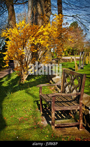 Un banco dal sagrato, un luogo tranquillo in cui rilassarsi presso il St Helen's Chiesa, Churchtown Foto Stock