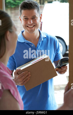 Corriere consegna pacchetto per ambiente domestico Foto Stock