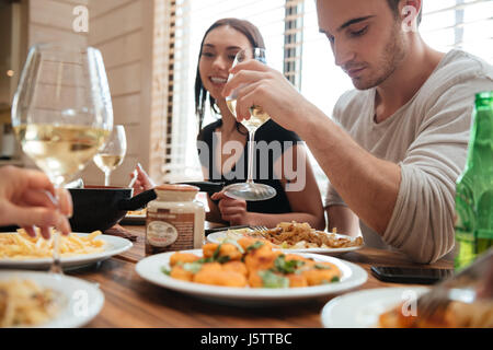 Bella coppia Giovane di mangiare e di bere il vino con gli amici in cucina a casa Foto Stock
