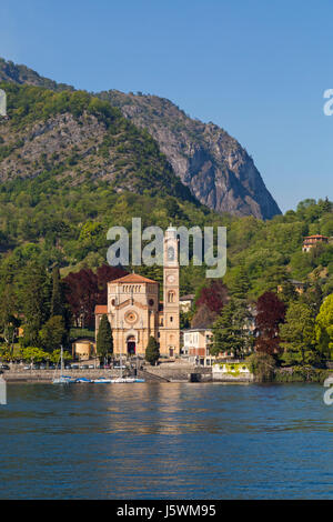 Vista da Lenno attraverso a Tremezzo con la chiesa di San Lorenzo Tremezzo Lago di Como, Italia nel mese di aprile Foto Stock