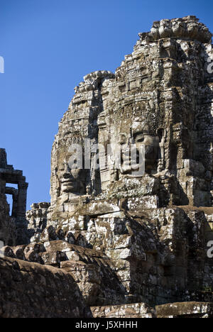 Enormi volti in pietra decorano il Bayon tempio buddista a Angkor Thom, Siem Reap, Cambogia. Foto Stock