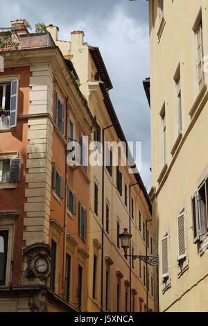 Clock esterno su un edificio da una strada stretta a roma Foto Stock