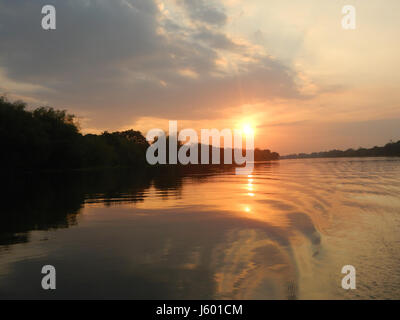 Questa immagine cattura i tramonti panoramici nei distretti fluviali di Calumpit, Bulacan, una provincia delle Filippine. Le vibranti vedute del tramonto riflettono la bellezza naturale e i paesaggi rurali tipici di questa regione. Foto Stock