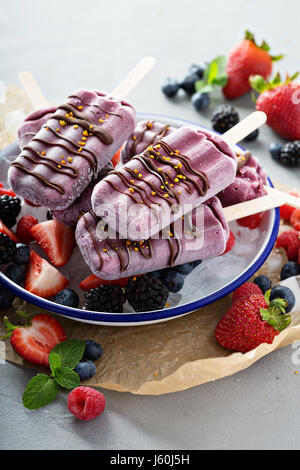 Di frutti di bosco misti popsicles con glassa di cioccolato Foto Stock