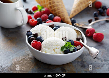 Gelato alla vaniglia sessole in una ciotola con frutti di bosco freschi Foto Stock