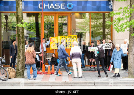 Persone che protestano tar sands pipeline in parte anteriore del Chase Bank, Seattle, Washington, USA Foto Stock