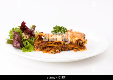 Pezzo di lasagne con insalata su una piastra Foto Stock