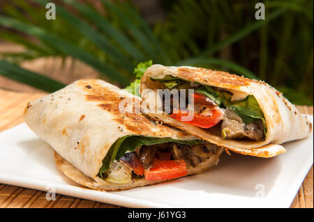 Vegetariano grigliato avvolgere su una piastra bianca all'aperto ai tropici Foto Stock