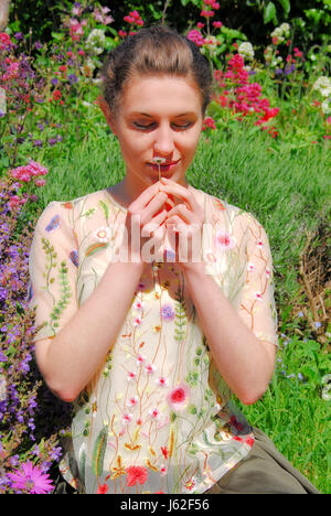Isola di Portland, Dorset, Regno Unito. 19 Maggio, 2017. Una giovane donna profumi di fiori in un soleggiato giardino Portland Credit: stuart fretwell/Alamy Live News Foto Stock