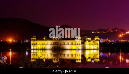 Vista panoramica della Jal Mahal (acqua) Palace si trova nel mezzo dell'uomo Sagar lago della sera con le luci della città, Amer, Jaipur, Rajasthan, India Foto Stock