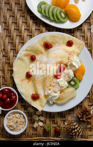 Bicchiere di frullato fragole e ghiaccio caffè con torta rossa del velluto sulla tavola di legno nella caffetteria. Foto Stock