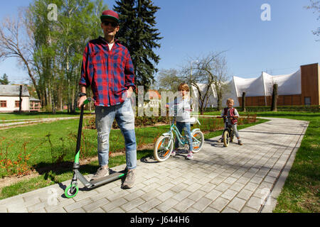 Uomo con i bambini su scooter Foto Stock