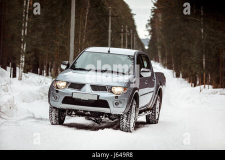 Suv corse su un inverno strada forestale Foto Stock