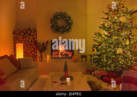 Ambient camino e candele in soggiorno con albero di Natale Foto Stock