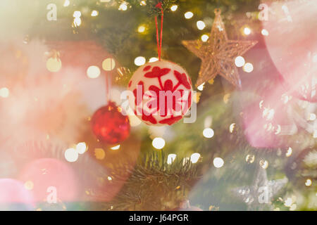 Rosso e bianco ornamento fiocco di neve appesi su albero di Natale Foto Stock