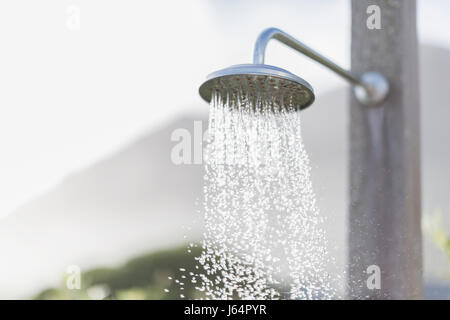 L'acqua che cade dalla doccia esterna testa Foto Stock