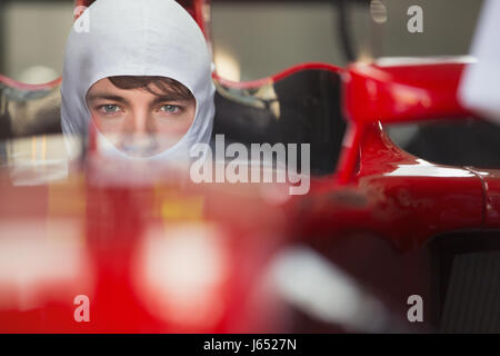 Close up ritratto grave gara di Formula Uno pilota di auto di indossare la maschera protettiva Foto Stock