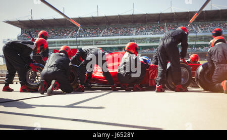 Pit Crew sostituiscono i pneumatici sulla gara di Formula Uno auto in pit lane Foto Stock