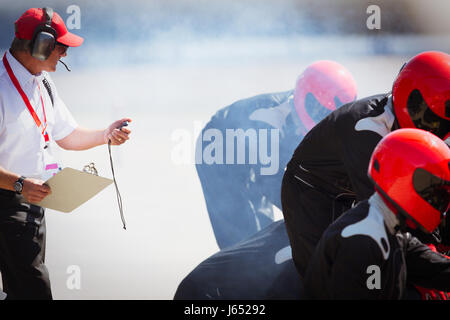 Manager con cronometro formula uno Pit Crew sessione di pratica Foto Stock