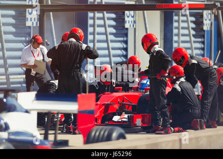 Pit Crew sostituiscono i pneumatici sulla gara di Formula Uno auto in pit lane Foto Stock
