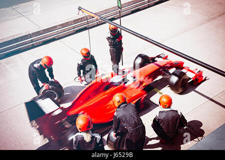 Pit Crew sostituiscono i pneumatici sulla gara di Formula Uno auto in pit lane Foto Stock