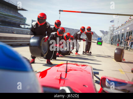 Pit Crew con pneumatici pronto per quasi gara di Formula Uno auto in pit lane Foto Stock