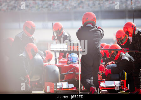 Pit Crew sostituiscono i pneumatici sulla gara di Formula Uno auto in pit lane Foto Stock