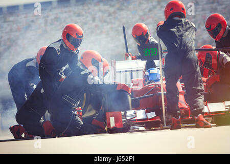 Pit Crew sostituiscono i pneumatici sulla gara di Formula Uno auto in pit lane Foto Stock