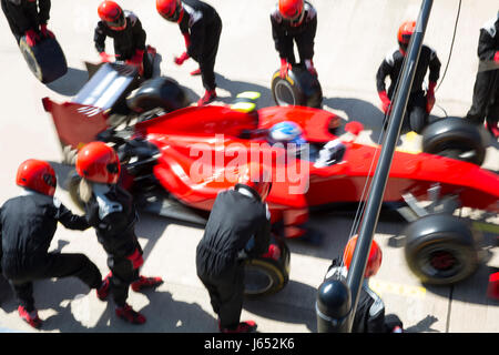 Pit Crew sostituiscono i pneumatici sulla gara di Formula Uno auto in pit lane Foto Stock